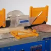 A hand is operating a woodworking machine, with sawdust flying. Produktbild-Vorschau