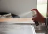 A hand sprays a cleaning product onto a stainless steel sink. Produktbild-Vorschau