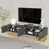 A modern, dark gray TV stand with gold accents, featuring open doors and shelves displaying decorative items, a lamp, and a television. Produktbild-Vorschau