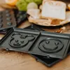 A close-up of a sandwich maker with cartoon character molds. Anteprima dell’immagine prodotto
