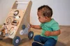 A baby playing with a wooden activity walker. Produktbild-Vorschau
