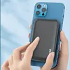 Hands holding a smartphone with a power bank attached to the back. Produktbild-Vorschau