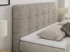 A close-up view of a beige upholstered bed with a tufted headboard and pillows. Produktbild-Vorschau