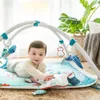 A baby is playing on an ocean-themed playmat with a play gym. Produktbild-Vorschau