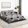 A bedroom scene with a bed made with a grey duvet cover and pillowcases featuring a geometric pattern. A bedside table with a clock and a plant are visible. Produktbild-Vorschau