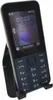 A black Nokia 225 4G feature phone is displayed on a black stand against a white background. Produktbild-Vorschau