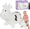 A white inflatable cow toy with black spots, a child riding a smaller version of the toy, and the product packaging in the background. Anteprima dell’immagine prodotto