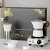 A coffee making set displayed on a table, with a gift box in the background. Produktbild-Vorschau