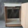 A close-up view of a sink cabinet with the door open, showing the plumbing underneath the sink. Podgląd zdjęcia produktu