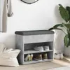 A shoe bench with storage is placed in a room, possibly an entryway, with shoes on its shelves and a plant nearby. Voir les images du produit