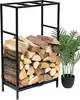 A black metal firewood rack filled with logs, next to a potted plant. Podgląd zdjęcia produktu