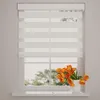 A window with white blinds and a vase of orange tulips on the windowsill. Produktbild-Vorschau