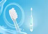 A close-up of an electric toothbrush head and a full electric toothbrush with a cartoon lion on a blue background with water splashes. Produktbild-Vorschau
