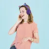 A young woman wearing purple cat-ear headphones and a striped t-shirt, listening to music and dancing. Náhľad obrázku produktu