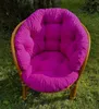 A fuchsia cushion on a rattan garden chair outdoors. Produktbild-Vorschau