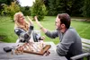 A couple high-fiving over a chess board in a garden. Podgląd zdjęcia produktu