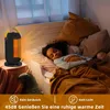 A child sleeping in bed, with a space heater on a side table emitting warm air. Anteprima dell’immagine prodotto