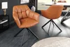 A modern dining room setting with two cognac leather swivel chairs and a dining table. Produktbild-Vorschau