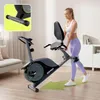 A woman is using a recumbent exercise bike in a living room. Produktbild-Vorschau