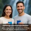 A man and a woman smiling and holding glasses of blue liquid in front of a waterfall. Produktbild-Vorschau