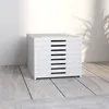 A stack of white shoe boxes on a light wooden floor, with a shadow of a plant on the wall behind. Náhled obrázku produktu