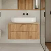 A modern bathroom vanity with a white vessel sink and wooden drawers. Voir les images du produit