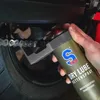 A hand is spraying lubricant onto a motorcycle chain. Produktbild-Vorschau