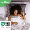 A woman sleeping peacefully under a comforter. Produktbild-Vorschau