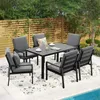 An outdoor dining set with chairs and a table on a patio next to a pool. Produktbild-Vorschau
