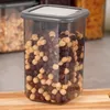 A close-up shot of a clear plastic food storage container filled with cereal, placed on a wooden surface. Anteprima dell’immagine prodotto