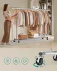 A woman is organizing clothes on a rolling garment rack, with close-ups of the rack's wheels and icons indicating features below. Náhled obrázku produktu
