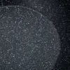A close-up view of the speckled surface of a frying pan. Náhled obrázku produktu