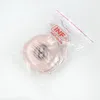 A pink ear cushion and headband pad for headphones is shown inside a clear plastic bag with a logo and website address printed on it. Voir les images du produit