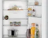 Inside view of a refrigerator with various food items on shelves. Produktbild-Vorschau