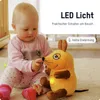 A baby is playing with a plush mouse toy that has a light on. Anteprima dell’immagine prodotto