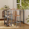 A bar table set with two stools and shelves, placed near a window with greenery outside. The table is set with glasses and a small cake. Podgląd zdjęcia produktu