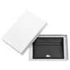 A black leather cardholder with the Lacoste logo is presented in a white box. Produktbild-Vorschau