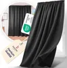 A close-up of a dark gray curtain with a tag and a certification label. Produktbild-Vorschau