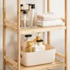 A close-up shot of a bamboo shelf unit displaying various toiletries and towels. Produktbild-Vorschau