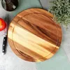 A wooden cutting board with a knife and an apple on a gray surface with a green cloth. Produktbild-Vorschau