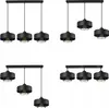 A collage of four different black pendant light fixtures, each with a metal shade and cage detail around the bulb. Podgląd zdjęcia produktu