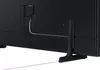 The back of a black television with a stand and a white cable management system. Produktbild-Vorschau