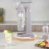 A Berlinger Haus Sodabar is shown on a kitchen counter with a glass of sparkling water and fruit. Produktbild-Vorschau