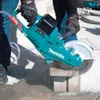 A person is using a Makita Akku-Trennschleifer to cut a concrete block. Voir les images du produit