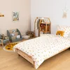A child's bedroom with a bed, rug, chair, and storage. Podgląd zdjęcia produktu