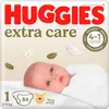 A close-up of a baby lying down, with Huggies Extra Care packaging in the background. Podgląd zdjęcia produktu