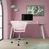 A pink velvet office chair is placed in front of a desk with a computer in a pink room. Náhled obrázku produktu