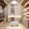 A modern closet or dressing room with built-in shelves and drawers, featuring a ceiling-mounted LED light. Produktbild-Vorschau