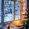 A cozy winter scene with Christmas lights decorating a frosted window, a lit candle, and a small Christmas tree on a windowsill. Produktbild-Vorschau