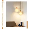 Two pendant lights hanging over a bench with decorative vases on a shelf. Produktbild-Vorschau